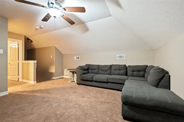 a living room with furniture and a ceiling fan