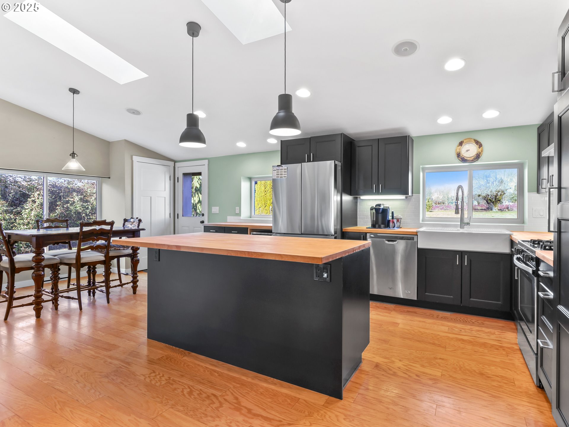 5714 Northwest 169th Street Ridgefield, WA 98642 - Photo 14 of 48 a kitchen with stainless steel appliances granite countertop a refrigerator a sink dishwasher a stove and a dining table with wooden floor