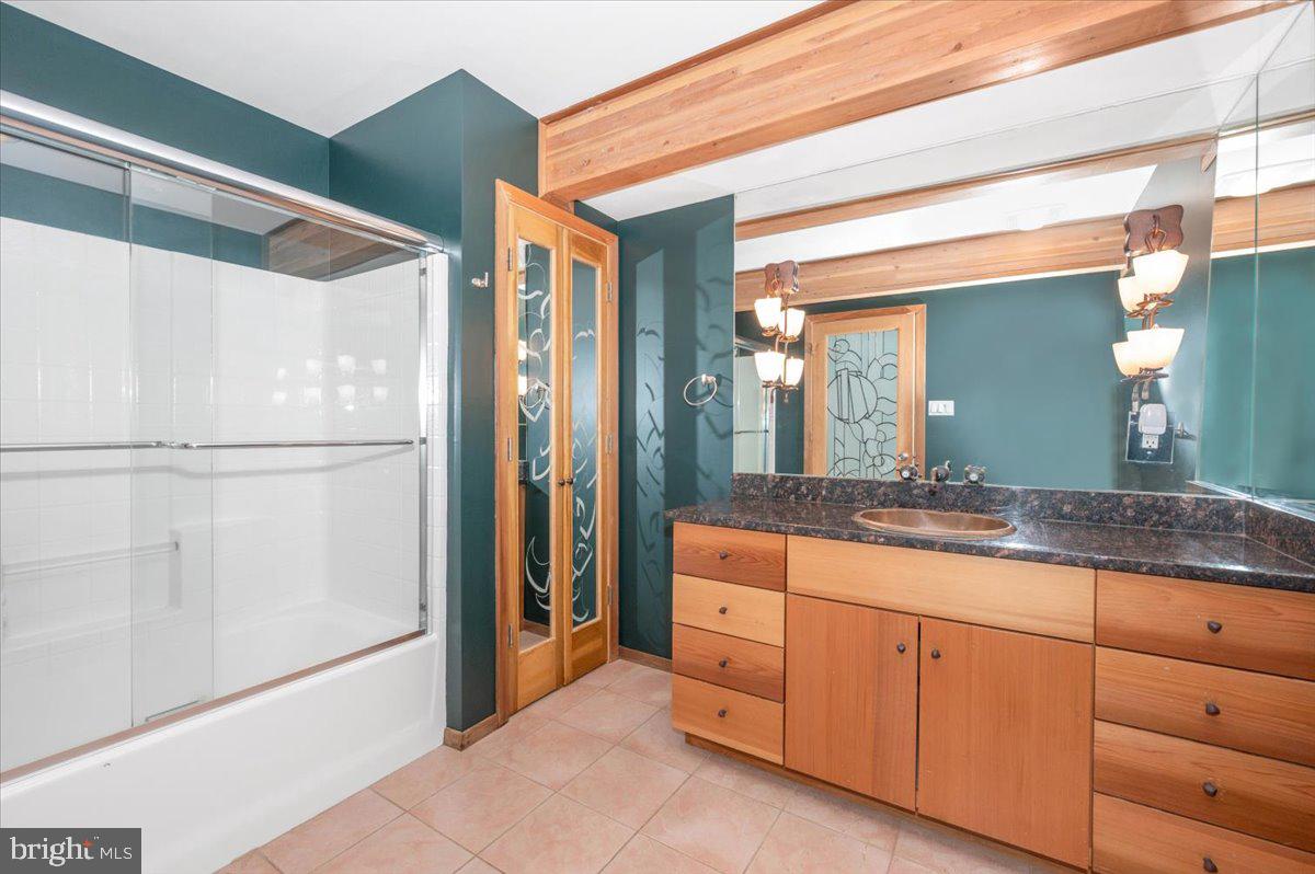 11127 Dublin Road Woodsboro, MD 21798 - Photo 36 of 62 a bathroom with a granite countertop sink a mirror and a shower
