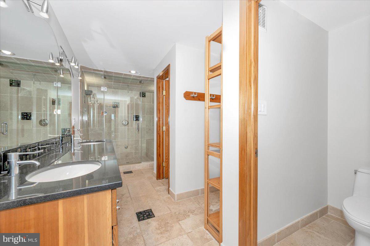 11127 Dublin Road Woodsboro, MD 21798 - Photo 55 of 62 a bathroom with a granite countertop sink a mirror and a shower