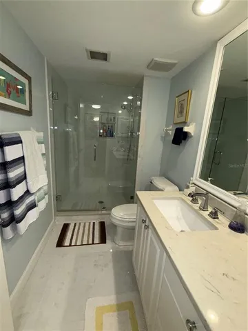 a bathroom with a sink a toilet a mirror and shower