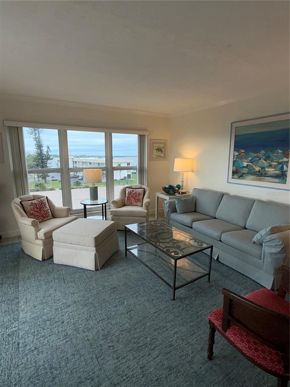 3240 Gulf Of Mexico Drive, Unit B402 Longboat Key, FL 34228 - Photo 2 of 15 a living room with furniture and a large window