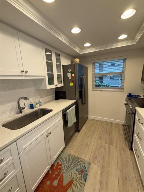 3240 Gulf Of Mexico Drive, Unit B402 Longboat Key, FL 34228 - Photo 5 of 15 a kitchen with a sink and wooden cabinets