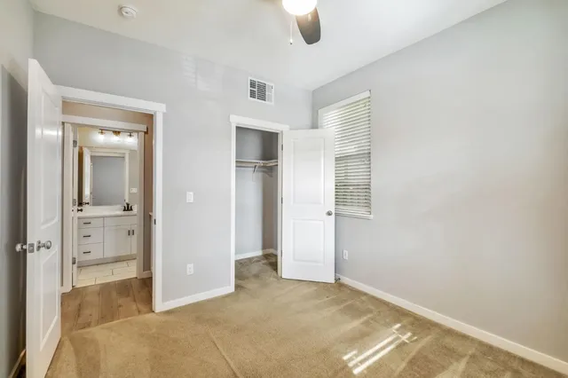 an empty room with closet and windows