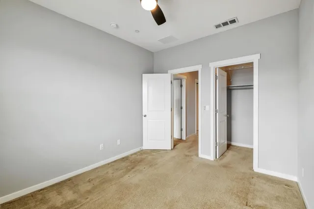 an empty room with window and closet area