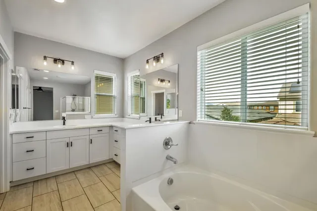 a bathroom with a tub sink and mirror