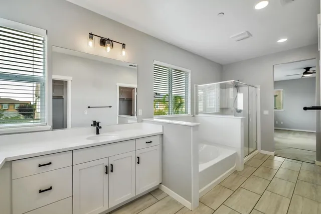 a spacious bathroom with a granite countertop sink mirror and bathtub