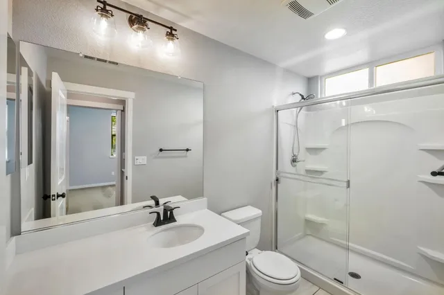 a bathroom with a sink a toilet and shower