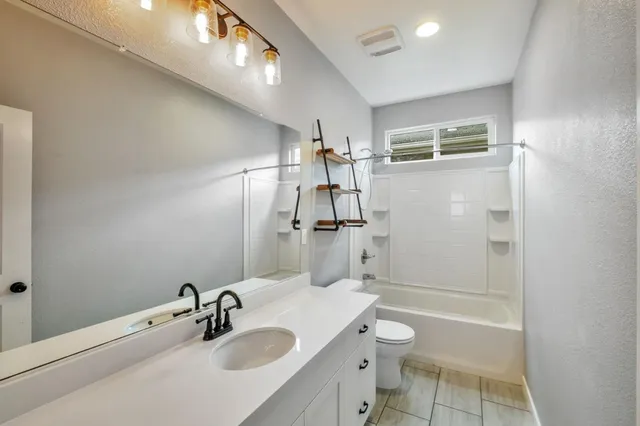 a bathroom with a sink toilet tub and shower