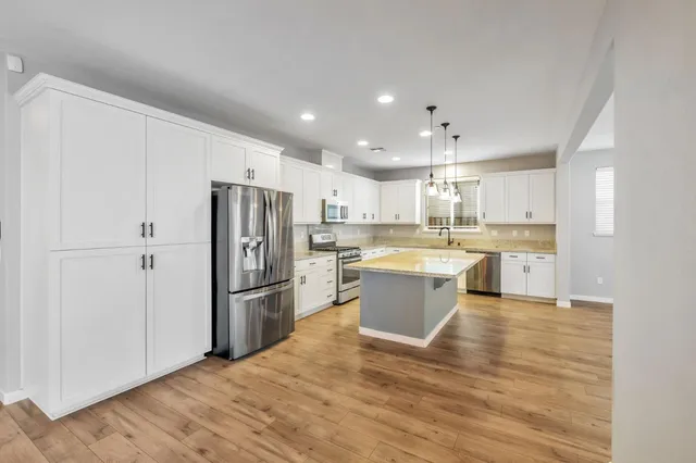 a large kitchen with a refrigerator and a sink