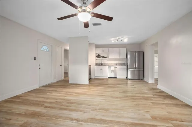 a view of a kitchen with a stove cabinets wooden floor and a ceiling fan