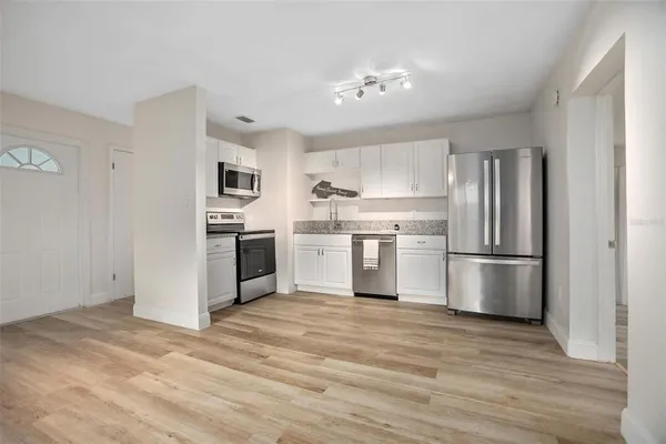 a kitchen with stainless steel appliances a refrigerator sink and white cabinets