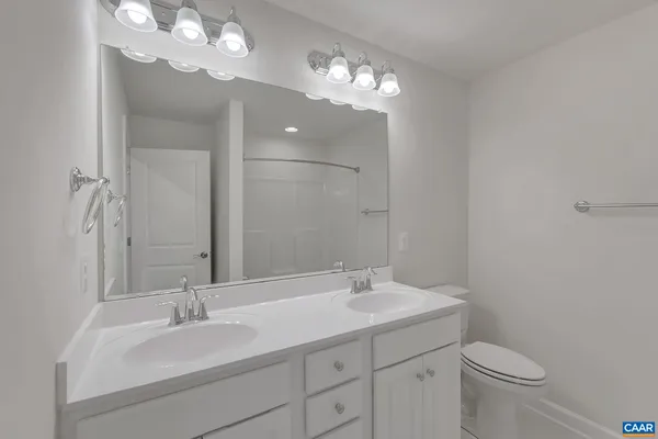 a bathroom with a toilet a sink and a mirror