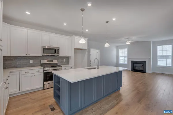 a large kitchen with kitchen island a sink stainless steel appliances and white cabinets