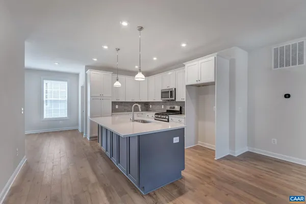 a kitchen with kitchen island a sink a center island stainless steel appliances and a window