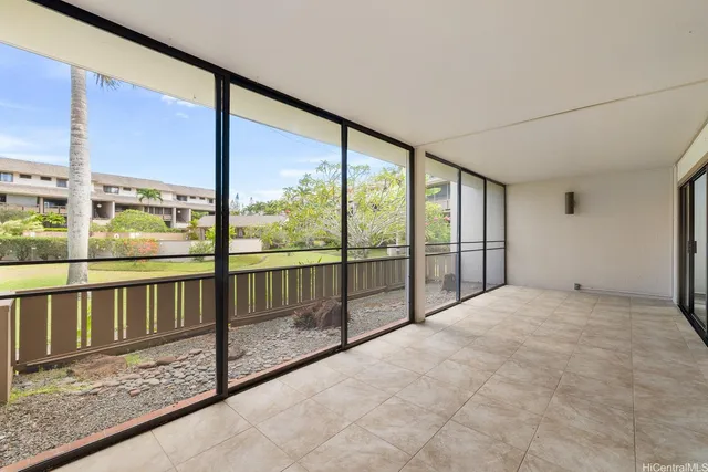 a view of an empty room with wooden floor and iron stairs