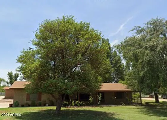 a front view of a house with a garden and trees