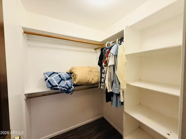 a bedroom with a bed dresser and wooden floor
