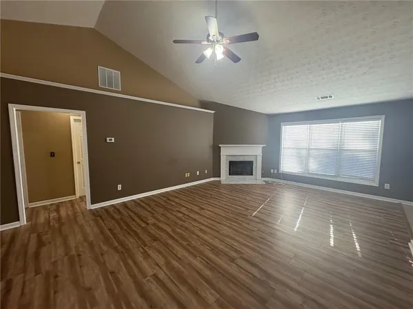 a view of a room with wooden floor and a fireplace