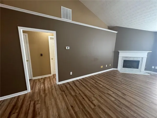 a view of an empty room with a window and fireplace