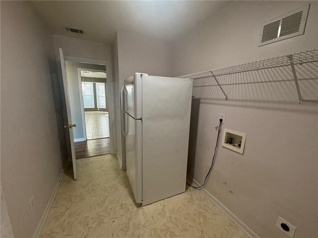 3452 Morning Top Place Suwanee, GA 30024 - Photo 31 of 33 a view of a refrigerator in kitchen and an empty room