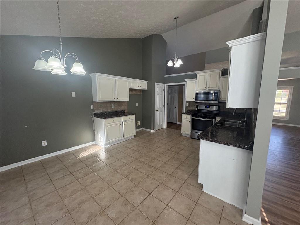 3452 Morning Top Place Suwanee, GA 30024 - Photo 8 of 33 a kitchen with stainless steel appliances a refrigerator a stove a sink a microwave and dining table