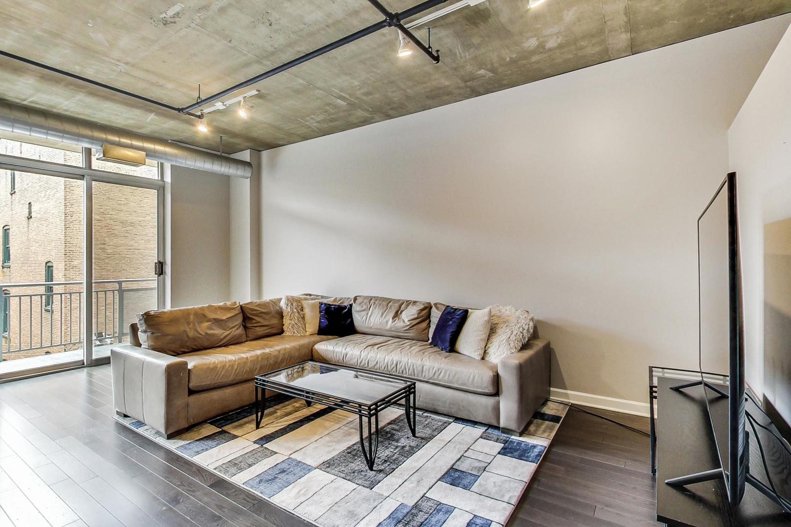 111 South Morgan Street, Unit 522 Chicago, IL 60607 - Photo 16 of 37 a living room with furniture and a rug