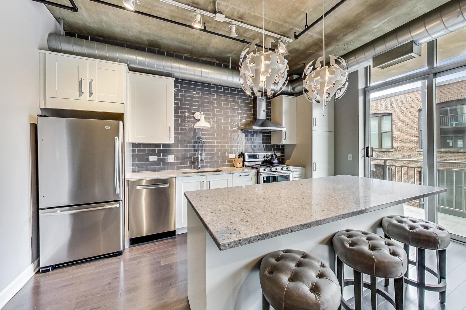 111 South Morgan Street, Unit 522 Chicago, IL 60607 - Photo 21 of 37 a kitchen with granite countertop a table chairs stove and refrigerator
