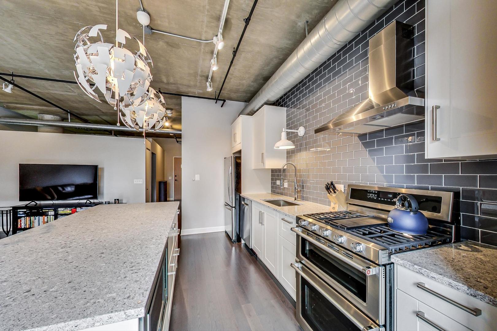 111 South Morgan Street, Unit 522 Chicago, IL 60607 - Photo 23 of 37 a kitchen with a stove and a chandelier