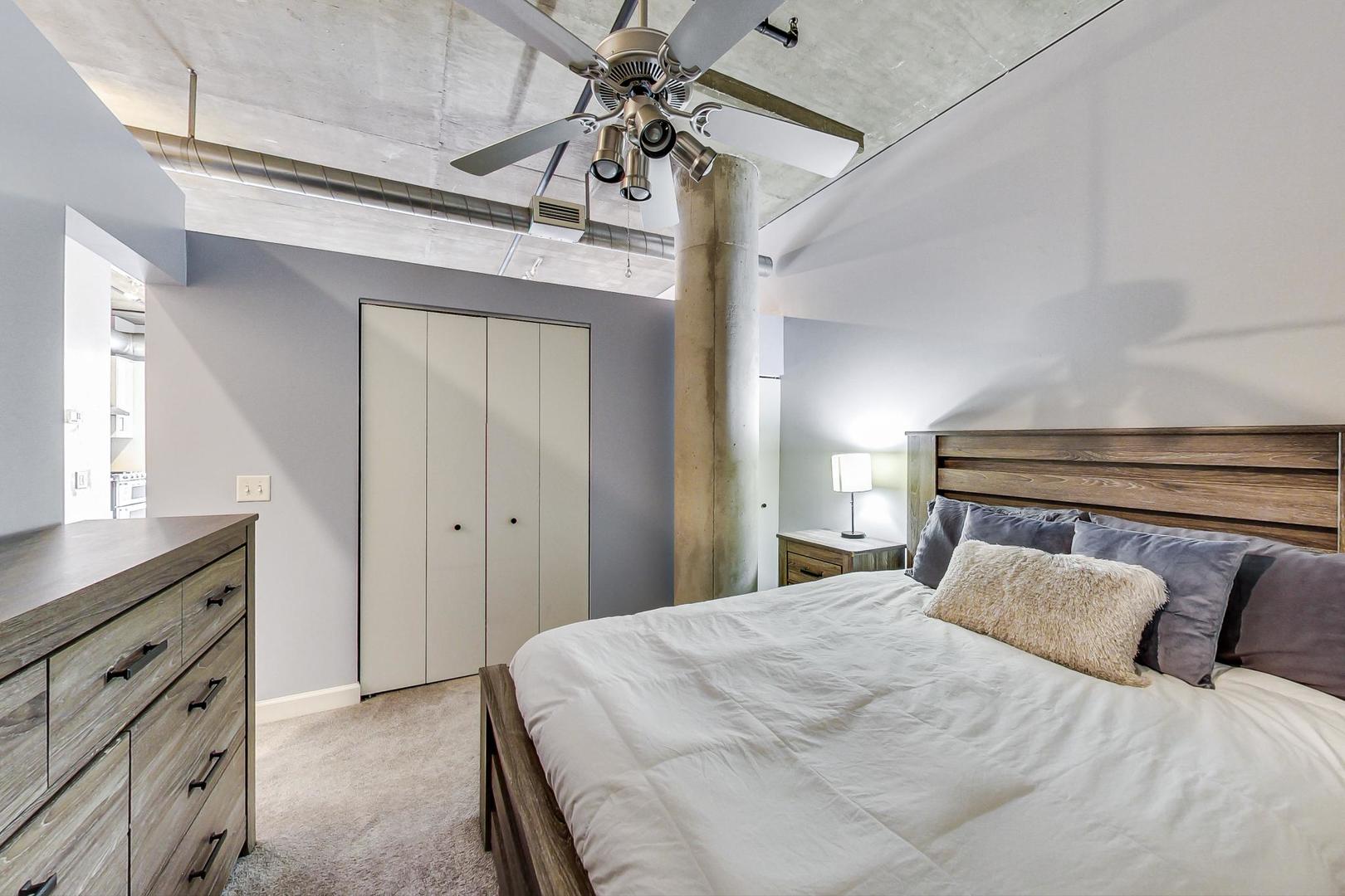 111 South Morgan Street, Unit 522 Chicago, IL 60607 - Photo 28 of 37 a bedroom with a large bed and a chandelier