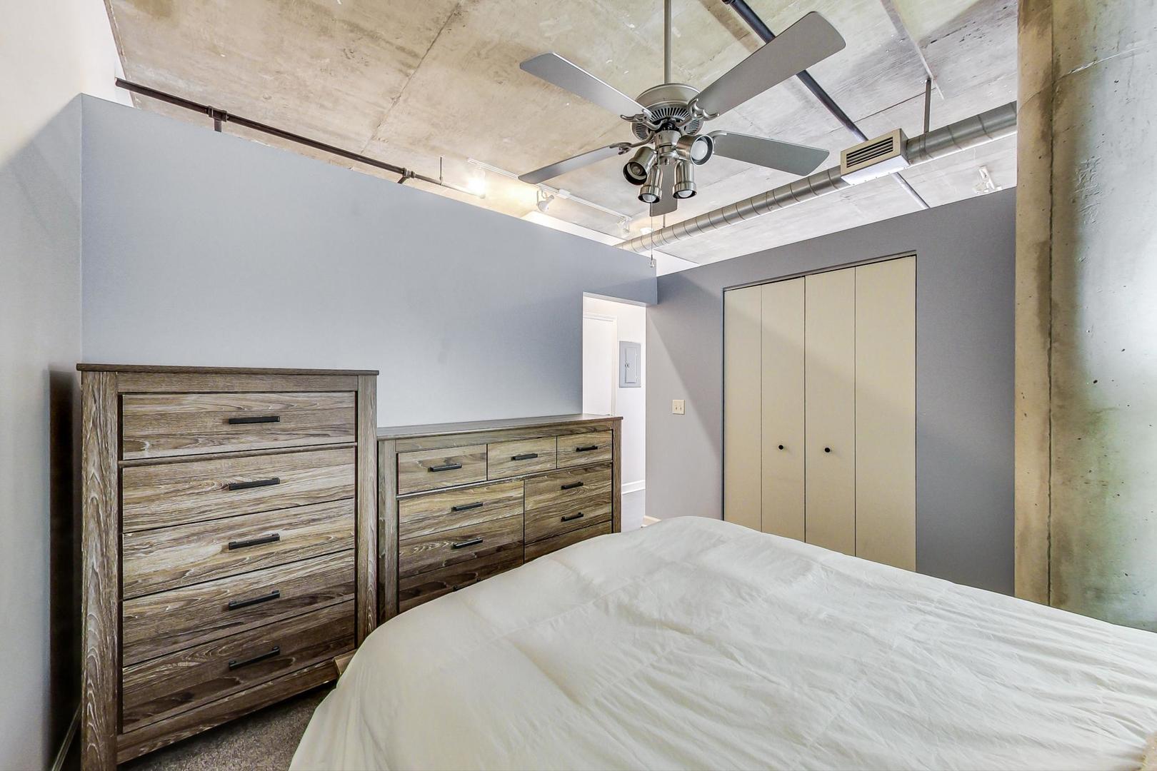 111 South Morgan Street, Unit 522 Chicago, IL 60607 - Photo 29 of 37 a bedroom with a bed and a chandelier
