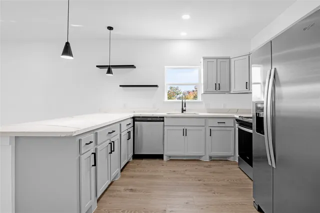 a kitchen with stainless steel appliances a sink stove and refrigerator