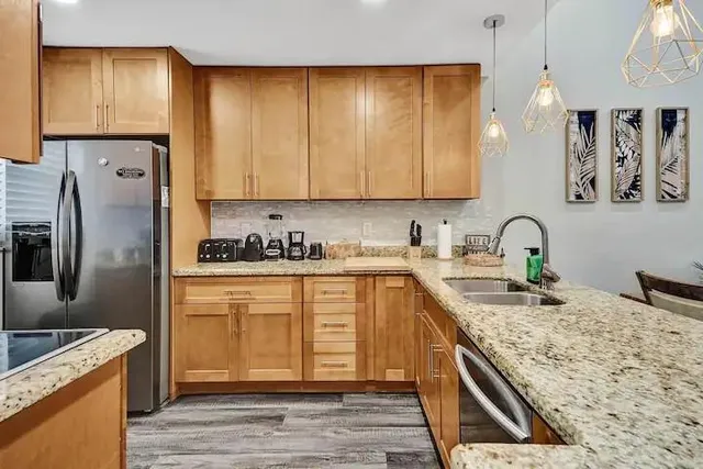 a kitchen with stainless steel appliances granite countertop a sink stove and refrigerator