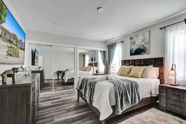 a bedroom with a bed and wooden floor