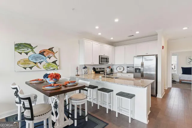 a kitchen with a sink a counter and chairs