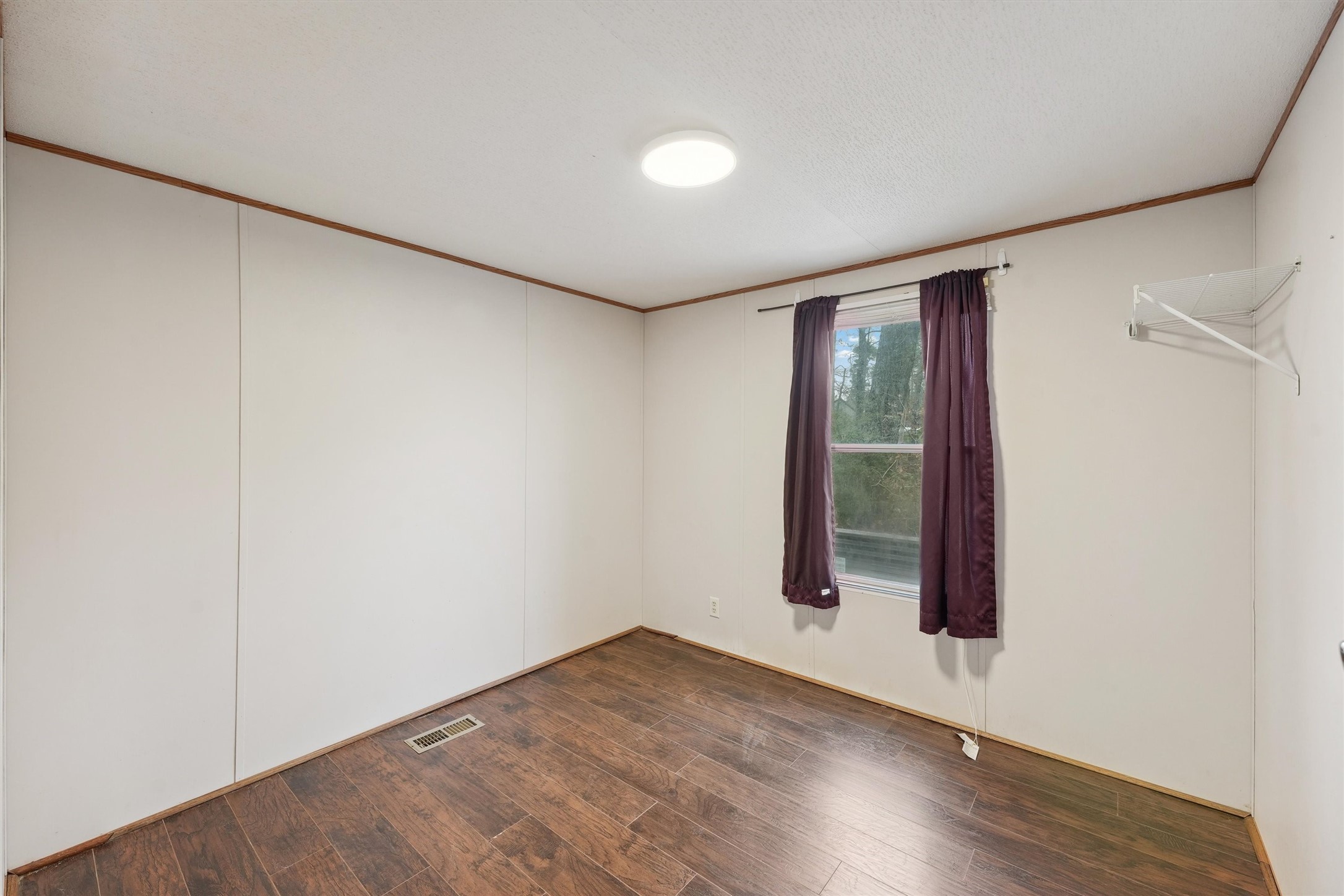 231 Monte Carlo Road Point Blank, TX 77364 - Photo 11 of 15 an empty room with wooden floor and windows