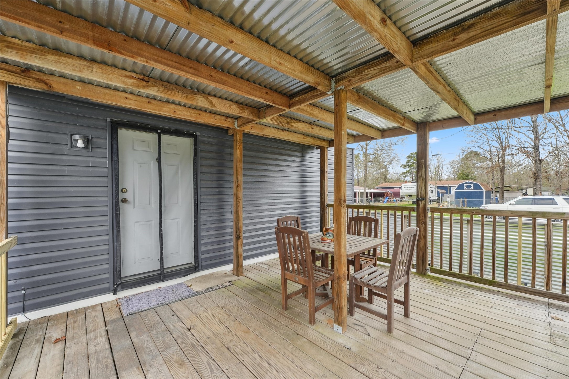231 Monte Carlo Road Point Blank, TX 77364 - Photo 2 of 15 a view of a patio with table and chairs and wooden floor