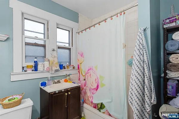 a bathroom with a sink a bath tub and a shower curtain