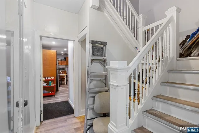 a view of a hallway with wooden floor and stairs