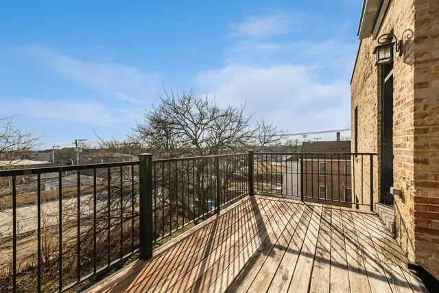 a view of balcony with wooden floor & fence
