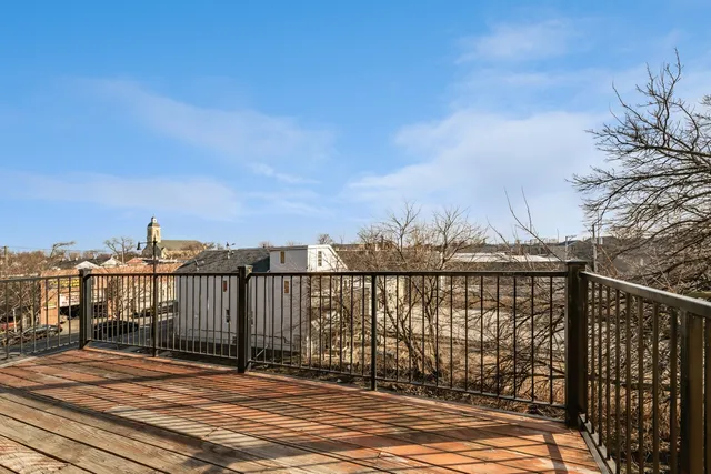 a view of a balcony with wooden floor and fence
