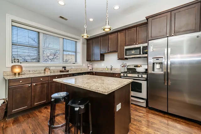 a kitchen with stainless steel appliances granite countertop a sink stove and refrigerator