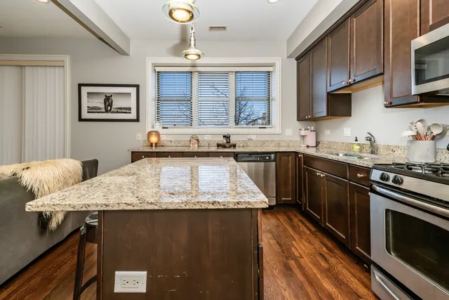 a kitchen with stainless steel appliances granite countertop a sink stove and microwave