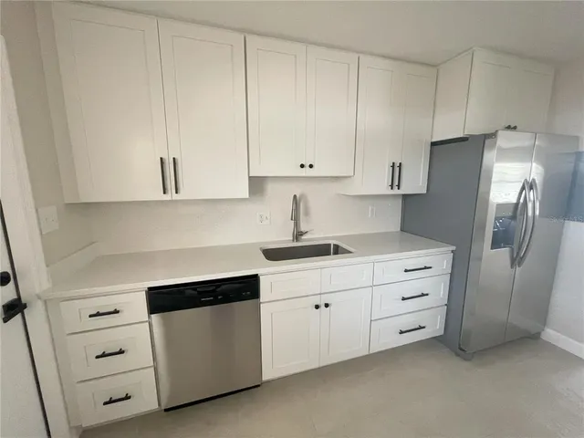 a kitchen with stainless steel appliances white cabinets and a stove top oven