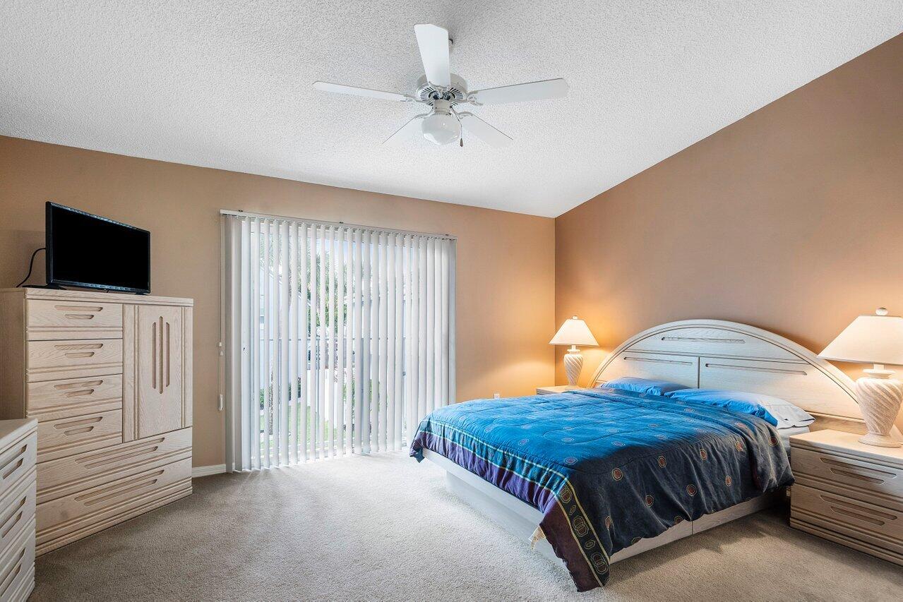 1050 Jeffery Street Boca Raton, FL 33487 - Photo 12 of 25 a spacious bedroom with a bed and a flat screen tv