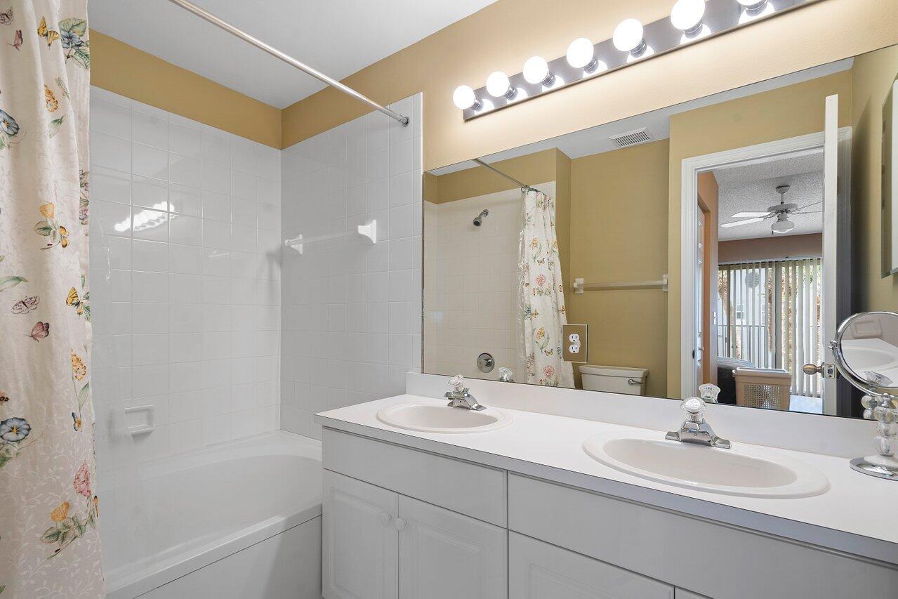 1050 Jeffery Street Boca Raton, FL 33487 - Photo 13 of 25 a bathroom with a double vanity sink and a mirror