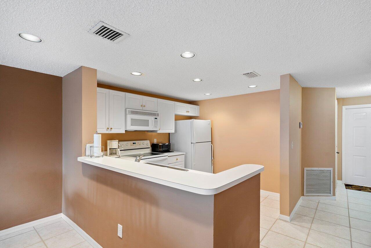 1050 Jeffery Street Boca Raton, FL 33487 - Photo 5 of 25 a kitchen with stainless steel appliances a refrigerator sink and microwave