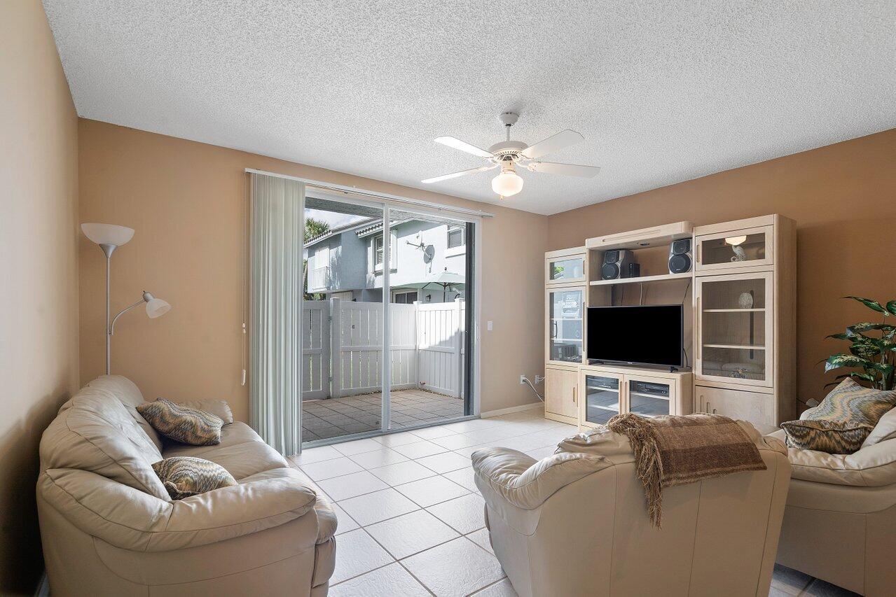 1050 Jeffery Street Boca Raton, FL 33487 - Photo 9 of 25 a living room with furniture a flat screen tv and a fireplace