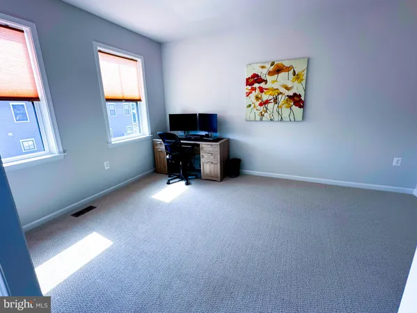 a bedroom with a bed table chair and a potted plant