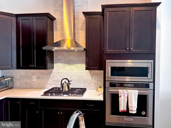 a kitchen with stainless steel appliances a sink stove refrigerator and cabinets